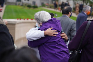 After the Rose-Laying Ceremony, members of the crowd hug, joining together to celebrate the lives lost.